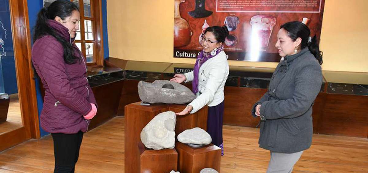 Gloria Palchisaca (c) muestra un mortero, la piedra y el calendario lunar, que se exhiben en el Museo de la Ciudad en el cant&oacute;n El Tambo.