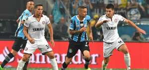 &rarr;Gremio y Lan&uacute;s midieron fuerzas el mi&eacute;rcoles pasado en el Arena de Porto Alegre. Luan (c.) traslada el bal&oacute;n en medio de dos volantes argentinos.