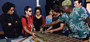 En el aula T&aacute;bara de la Universidad de las Artes, en Guayaquil, Sa&uacute;l Torres (d) explica a los estudiantes las partes de una marimba tradicional y c&oacute;mo se la construye. Las l&aacute;minas se hacen de madera chonta o pambil.