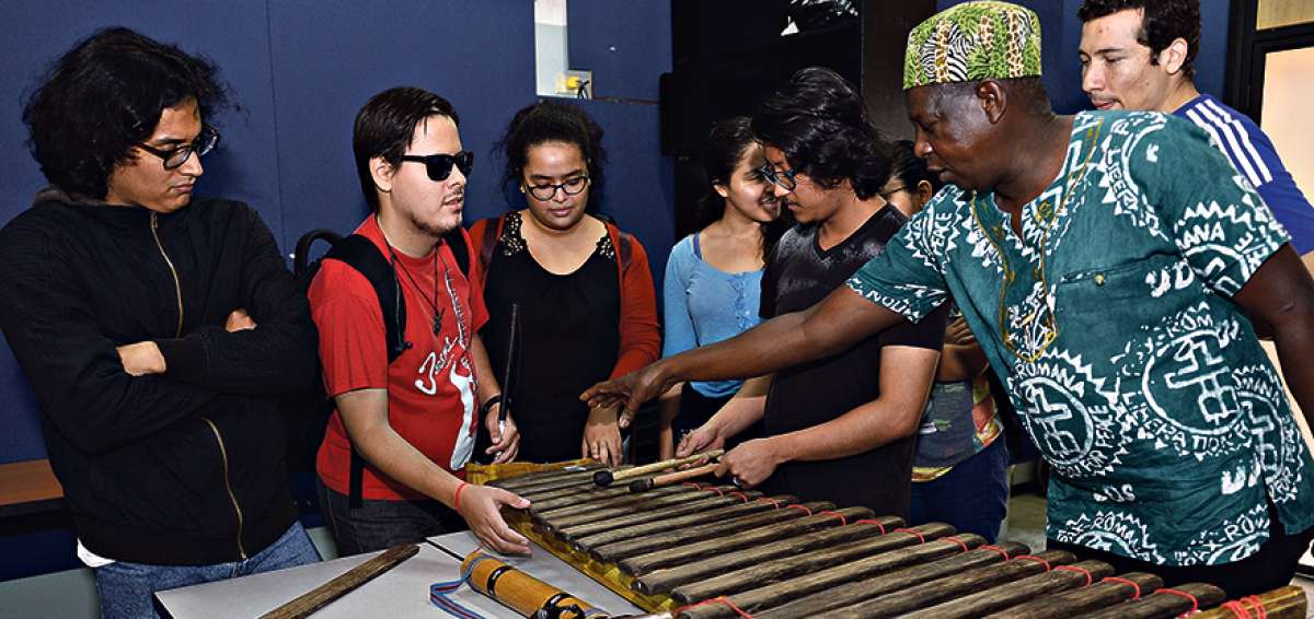 En el aula T&aacute;bara de la Universidad de las Artes, en Guayaquil, Sa&uacute;l Torres (d) explica a los estudiantes las partes de una marimba tradicional y c&oacute;mo se la construye. Las l&aacute;minas se hacen de madera chonta o pambil.