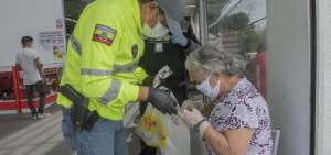 En el supermercado Santa Mar&iacute;a, en el sector de Carapungo, efectivos policiales adem&aacute;s de controlar las filas asisten a personas de la tercera edad. 