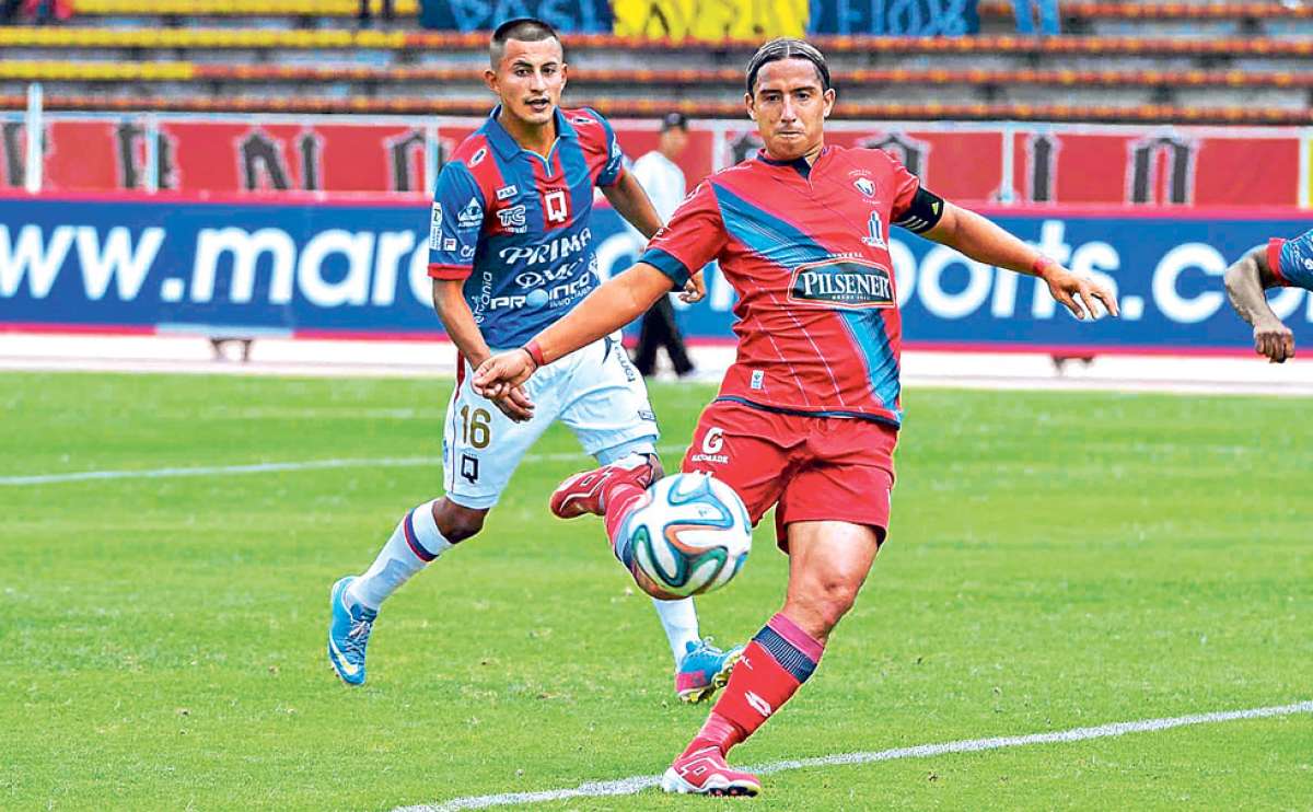 El capit&aacute;n de El Nacional, Marwin Pita (centro), remata ante la mirada del defensor deL Deportivo Quito Michel Castro, ayer en el Ol&iacute;mpico Atahualpa. Foto: Miguel Jim&eacute;nez / El Tel&eacute;grafo.