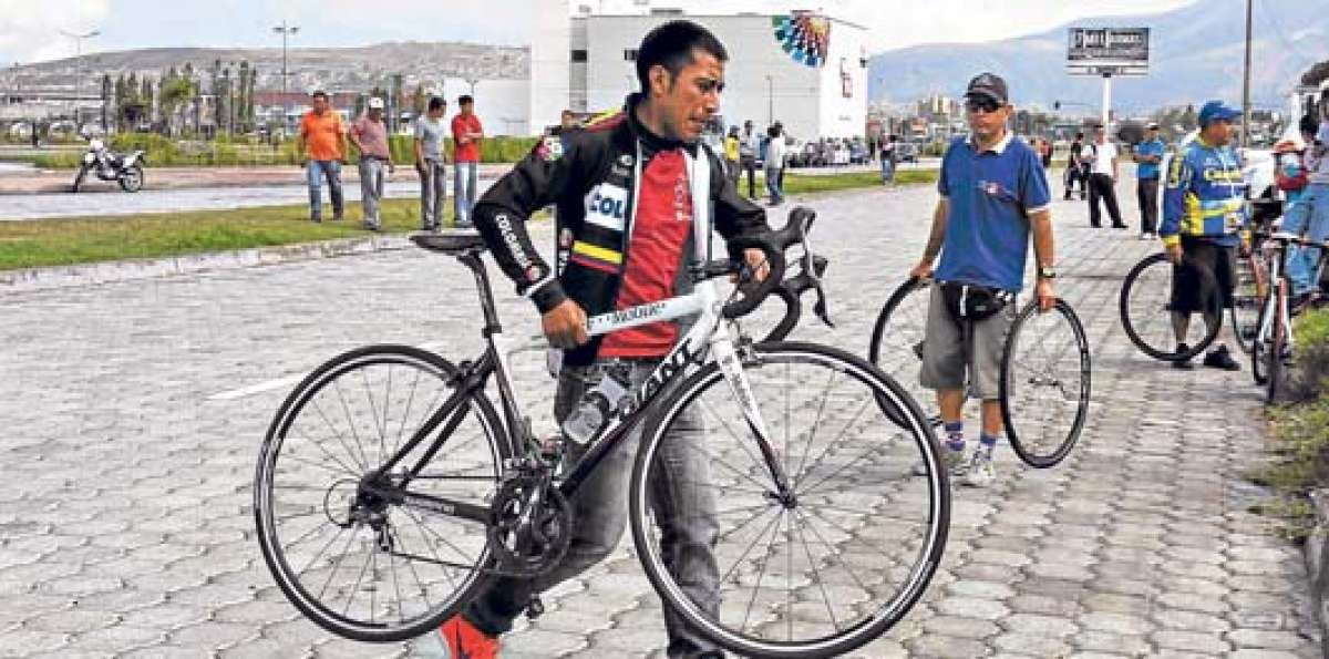 &Aacute;lex Atapuma lleva una de las bicicletas del equipo, luego de una de las etapas de la Vuelta Cicl&iacute;stica. Foto: &Aacute;lvaro P&eacute;rez.