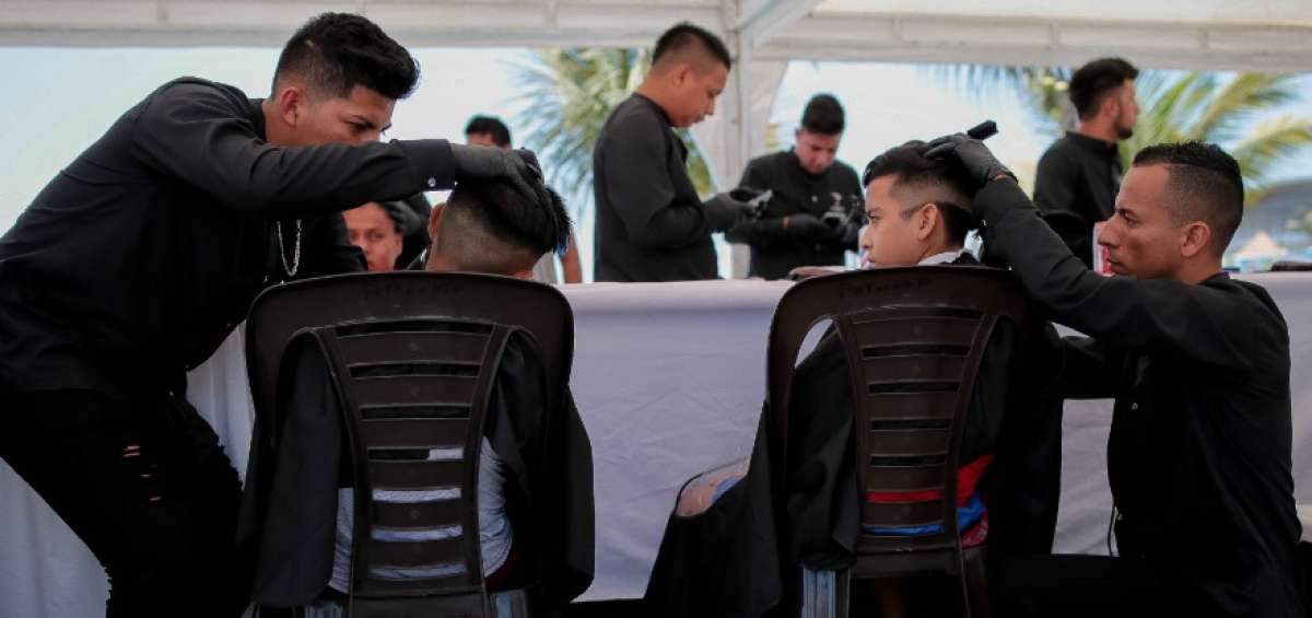 Barberos Solidarios de Manta cortan cabello a pie del mar