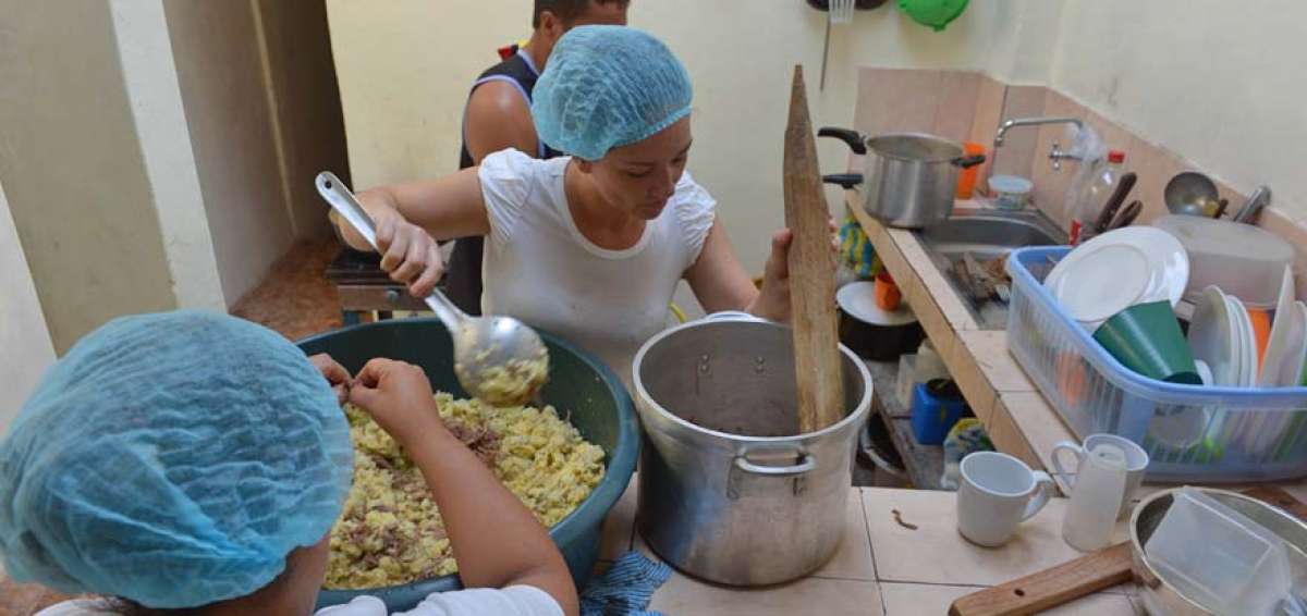 Nelly (de espaldas) ayuda a preparar las empanadas precocidas que vende en varios puntos de la ciudad.