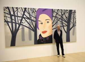 El artista posa junto a uno de sus cuadros que se exhiben en el Guggenheim. Foto AFP