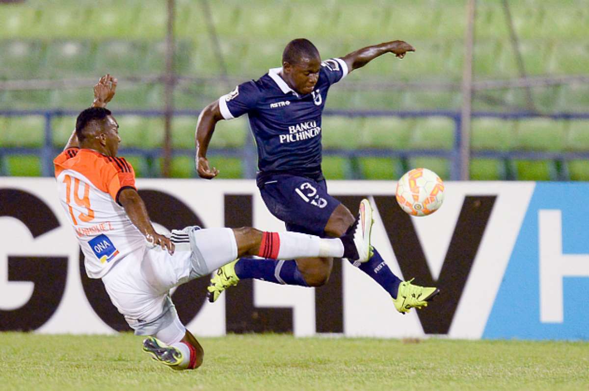 Jimmy Delgado (d.), jugador de U. Cat&oacute;lica, intenta desbordar y quedarse con el bal&oacute;n, pero Jos&eacute; Manr&iacute;quez (i.) desde el piso logra despejar la pelota. Foto: AFP