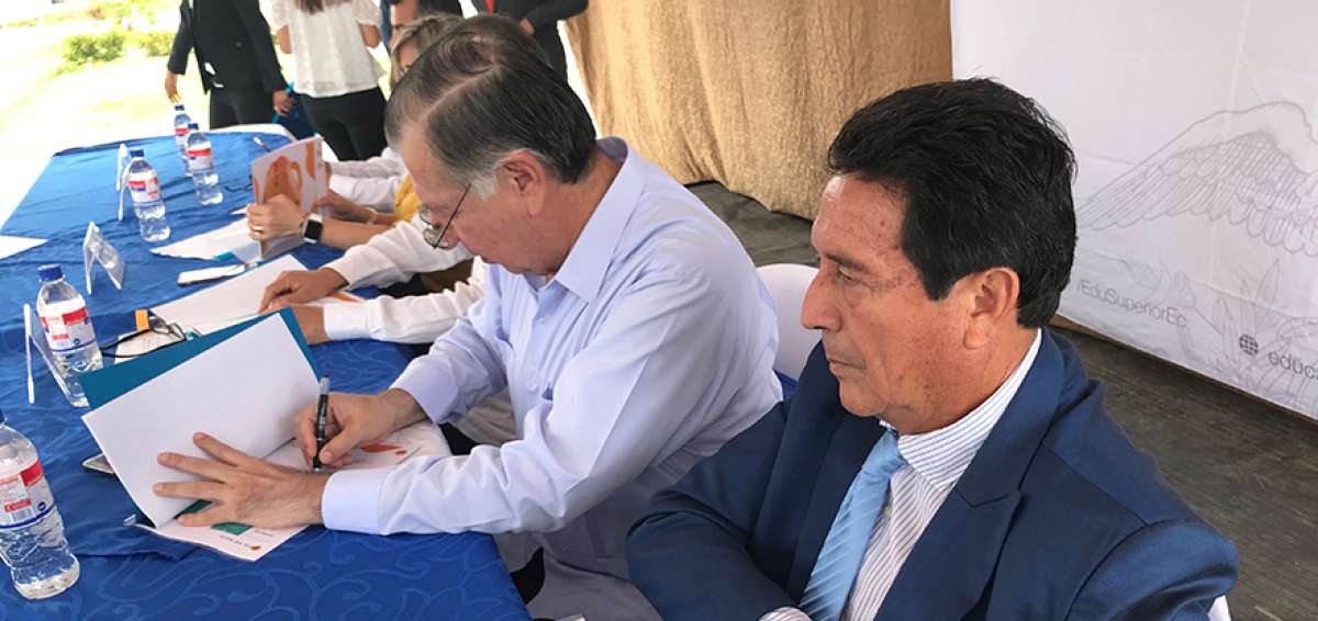 El rector de la UTM, Vicente V&eacute;liz, firma el recibimiento de las tierras.