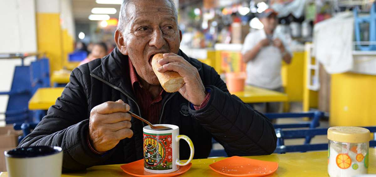 Arturo Mora disfruta de un caf&eacute;  acompa&ntilde;ado de pan con nata. Lleva visitando el mercado  m&aacute;s de 50 a&ntilde;os, donde compra las golosinas que ofrecen los comerciantes