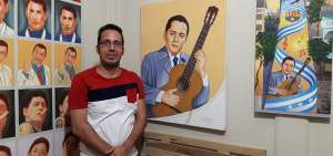 Moreano posa con algunos de los retratos que ha elaborado, entre ellos destaca el del cantante guayaquile&ntilde;o Julio Jaramillo Laurido.