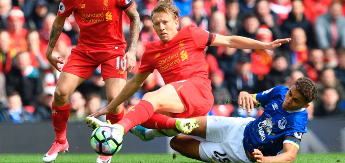 Dominic Calvert-Lewin (azul), del Everton, traba al brasile&ntilde;o Lucas Leiva, del Liverpool. Coutinho, autor del segundo gol del partido, sigue la acci&oacute;n de cerca.