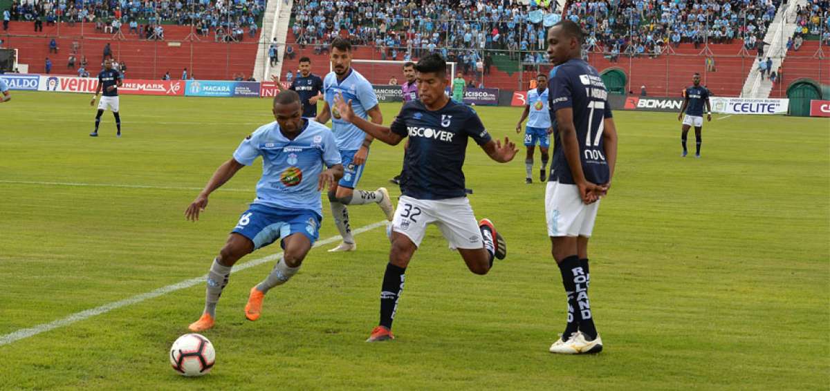 El jugador de Macar&aacute;, Galo Corozo (izq.), disputa el bal&oacute;n con el delantero Bruno Vides, de Universidad Cat&oacute;lica, ante la presencia de Yuber Mosquera.