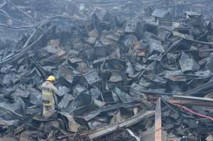 Los bomberos refrescaban los escombros ayer. El espacio afectado supera los 10 mil metros cuadrados. Foto: William Orellana / El Tel&eacute;grafo.