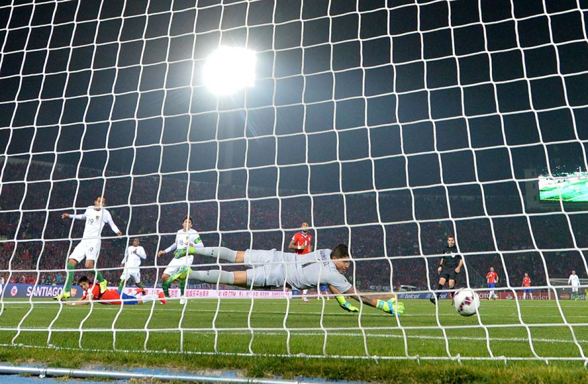 Momento en que el delantero chileno Alexis S&aacute;nchez (a la izquierda en el suelo) marca el segundo tanto del partido. El arquero Romel Qui&ntilde;&oacute;nez qued&oacute; vencido. Foto: AFP
