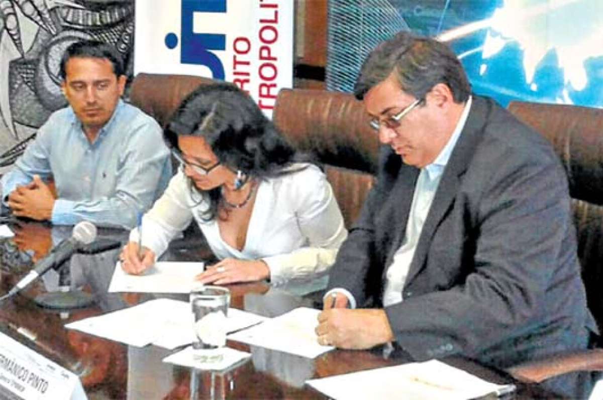 Germ&aacute;nico Pinto, de la Epmmop (der.), y Pilar Troya, de la Senescyt, firman el convenio. FOTO: CORTES&iacute;A MUNICIPIO