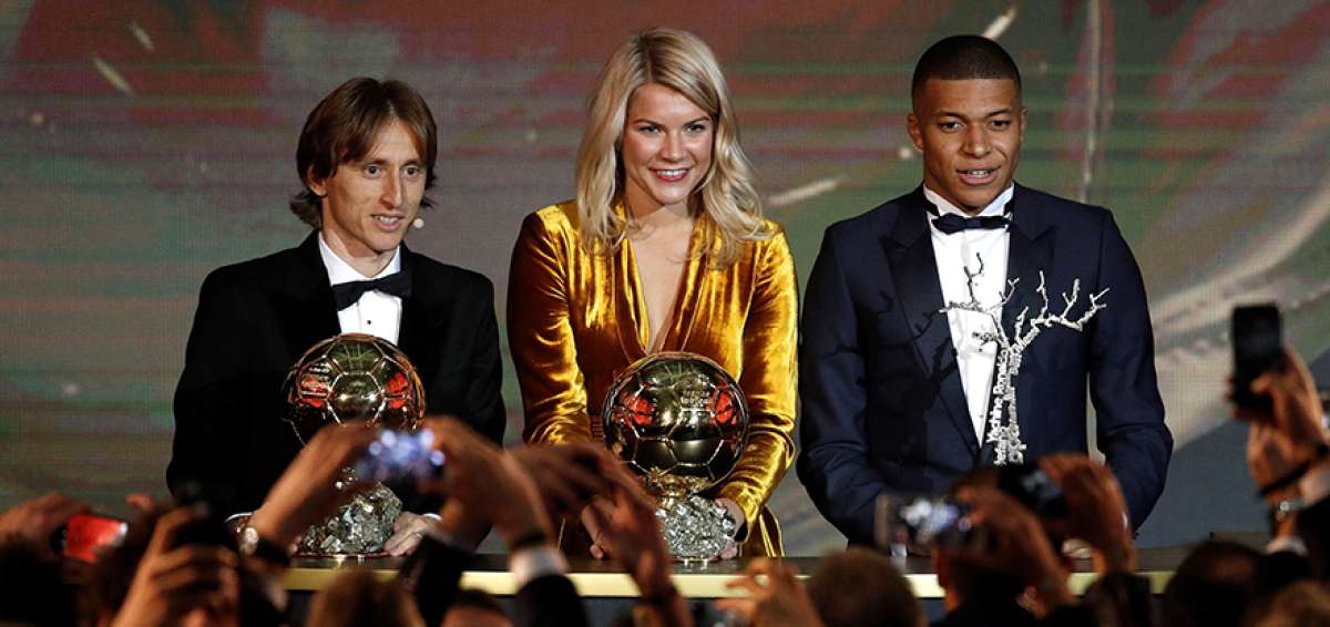 Ada Hegerberg (centro), Luka Modric (izq.) y Kylian Mbapp&eacute; (der.) posan ante el p&uacute;blico con los trofeos que los convierte en los mejores futbolistas del a&ntilde;o. Los galardones fueron entregados por la revista France Football.