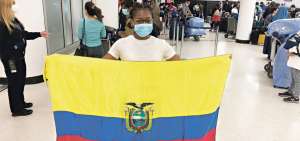 Antes de tomar su vuelo en Miami, la atleta Marizol Land&aacute;zuri extendi&oacute; la bandera ecuatoriana en muestra de agradecimiento por la ayuda recibida.