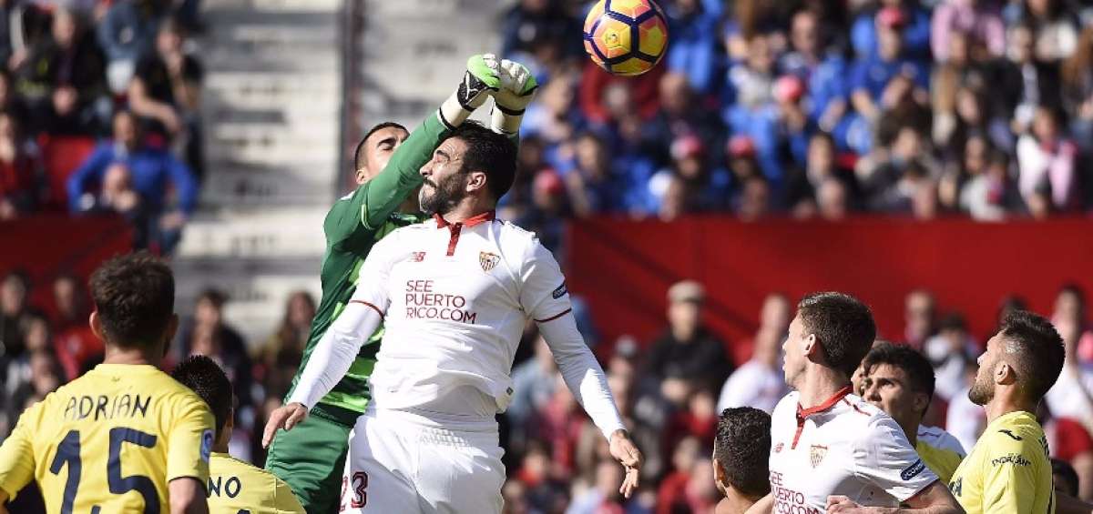 El arquero del Villarreal, Sergio Asenjo, rechaza la pelota en un ataque del defensa Adil Rami (23).