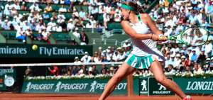 La tenista de Letonia, Jelena Ostapenko, espera la pelota para rematar -con la raqueta- con las dos manos.