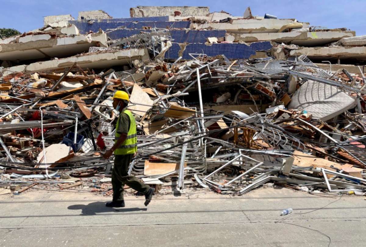 Un hombre camina frente a escombros de una edificaci&oacute;n derrumbada por terremotos este jueves, en La Guaira (Venezuela). 