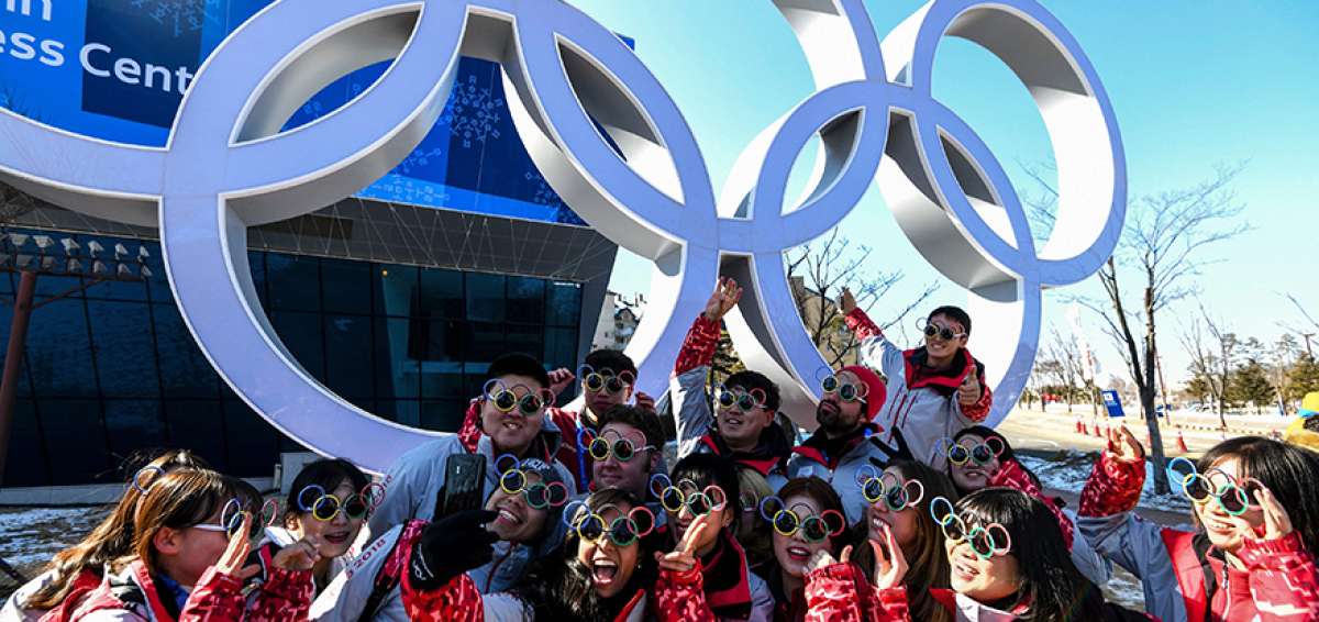 Un grupo de voluntarios posa afuera del estadio donde ma&ntilde;ana se inaugurar&aacute;n los Juegos de Invierno Pyeongchang 2018.