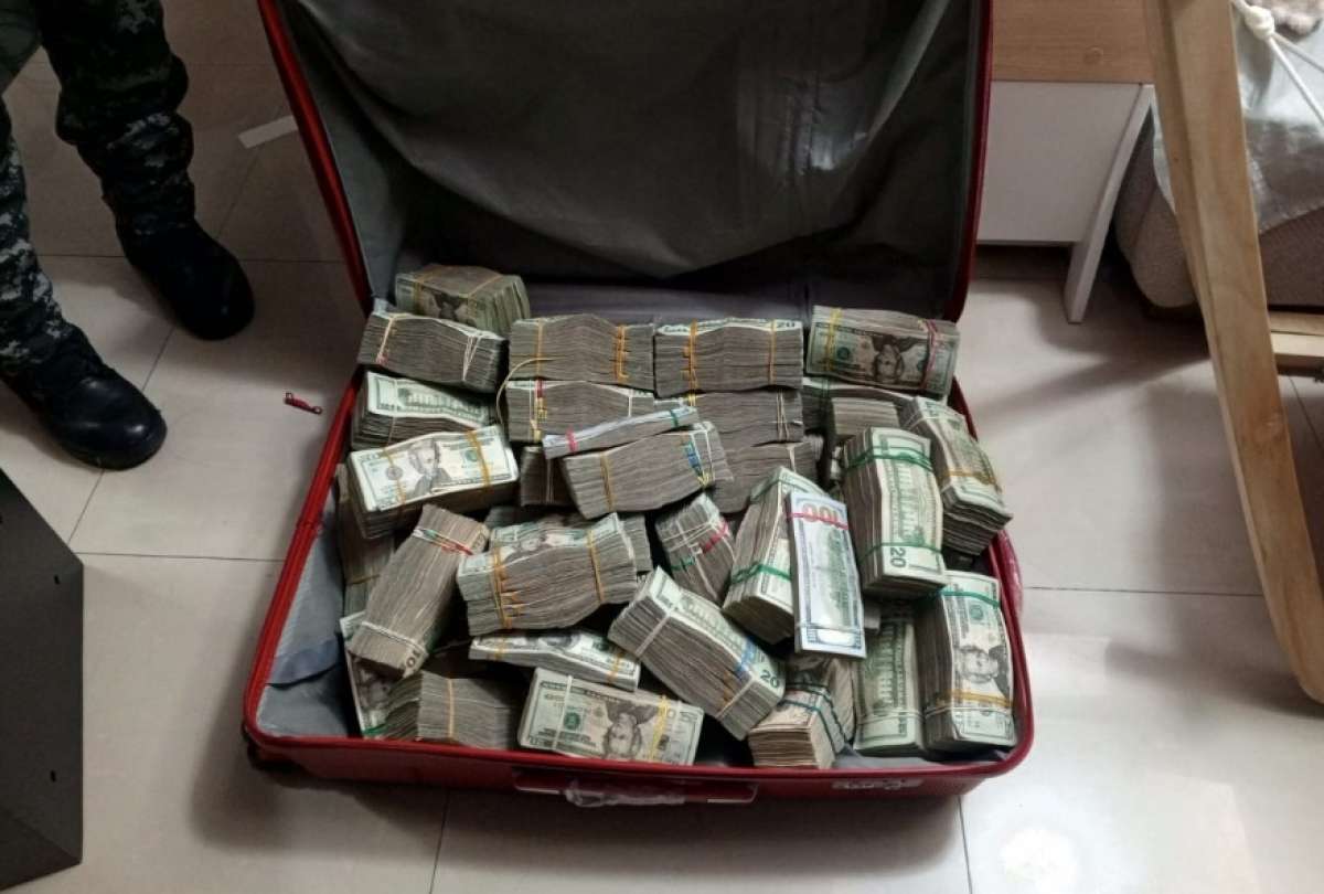 En uno de los allanamientos se halló una maleta con fajos de billetes de USD 20 y USD 100.