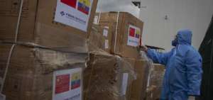 Un miembro de la Polic&iacute;a Nacional observa cajas con insumos donados por la C&aacute;mara de Comercio de Empresas Chinas para combatir la enfermedad causada por el nuevo coronavirus (covid-19) en Ecuador, en el aeropuerto Mariscal Sucre, en Quito-