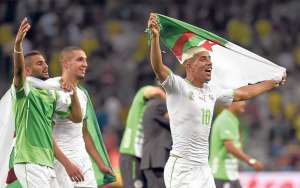 El jugador de Argelia, Sofiane Feghouli (derecha), celebra la clasificaci&oacute;n a octavos de final con su bandera. Foto: AFP