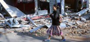 Una mujer camina junto a un edificio derruido en Lombok (Indonesia) tras el terremoto de magnitud 6,9 que sacudi&oacute; la noche del domingo. 