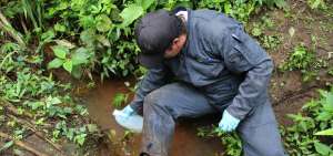 Un t&eacute;cnico del Ministerio de Ambiente (MAE) toma muestras de las aguas del r&iacute;o Pove, destinadas a determinar el nivel de contaminaci&oacute;n de ese cauce.