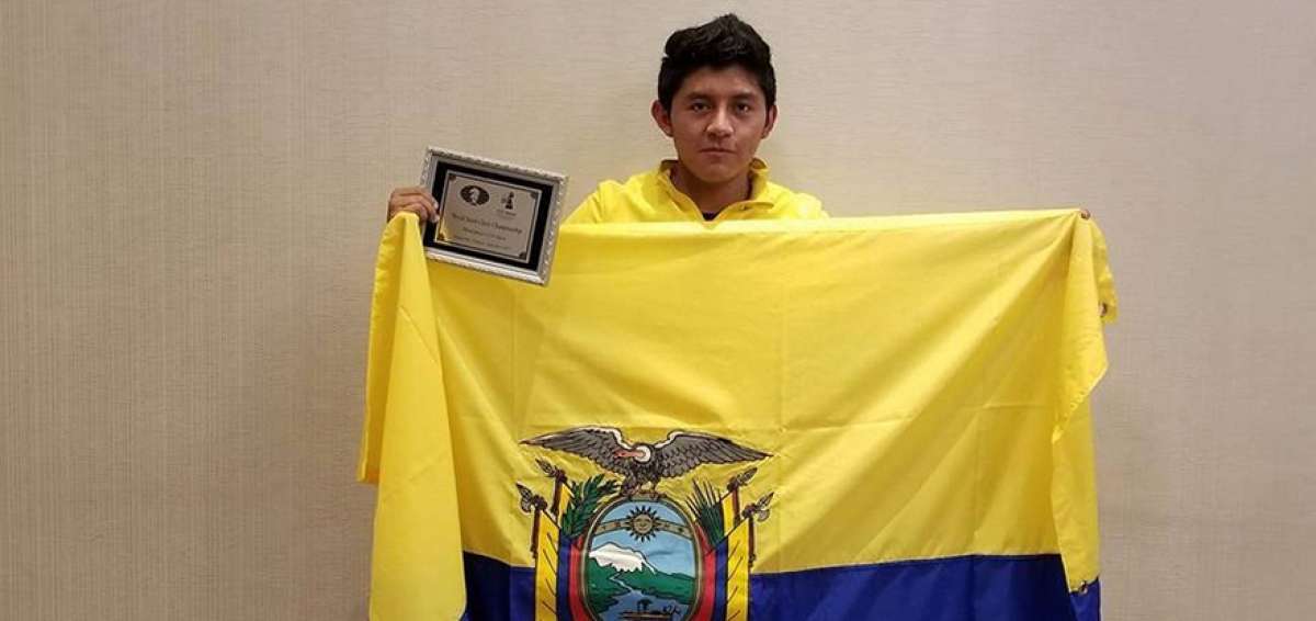 Kevin Noboa posa con una placa y la bandera ecuatoriana durante la premiaci&oacute;n del certamen internacional. 