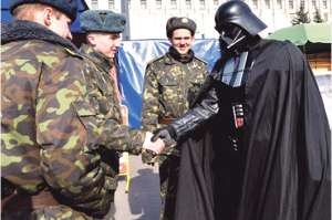 Ucrania.- Un hombre disfrazado del malvado Darth Vader estrecha la mano de unos militares ucranianos en Kiev. Foto: AFP.