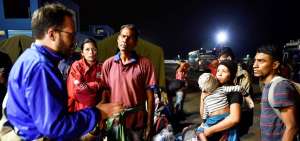 Un oficial de la Agencia para los Refugiados de las Naciones Unidas conversa con migrantes venezolanos que llegaron la noche del s&aacute;bado a Huaquillas, frontera con Per&uacute;. 