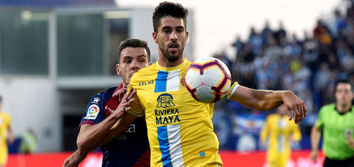 El Espanyol (uniforme amarillo) impuso su mayor eficacia ante el Huesca para colocarse provisionalmente segundo a un solo punto del Barcelona.