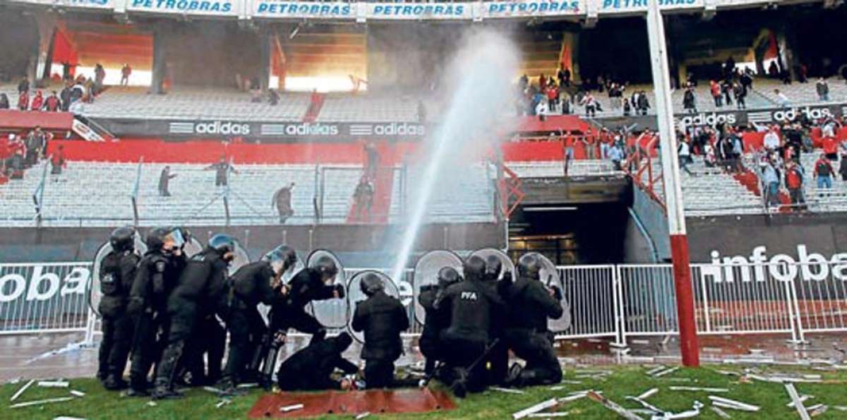 Un grupo de polic&iacute;as argentinos intenta controlar a hinchas de River Plate lanz&aacute;ndoles chorros de agua. Foto: Inetrnet.