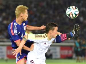 Luis Manuel Seijas (d.) de Venezuela disputa el bal&oacute;n con el japon&eacute;s Keisuke Honda. Foto: AFP
