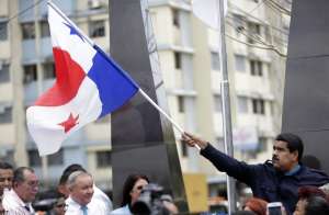 El presidente Nicol&aacute;s Maduro ondea una bandera paname&ntilde;a en su visita  a la barriad de El Chorrillo. FOTO: AFP 