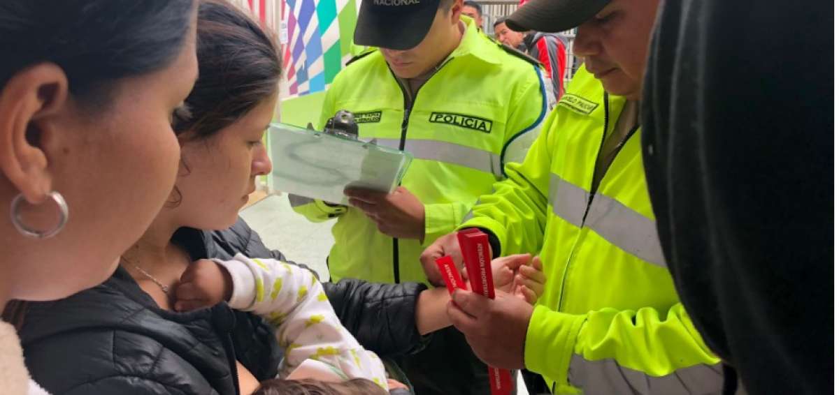 Personal de Migraci&oacute;n coloca brazaletes a venezolanos con atenci&oacute;n prioritaria.