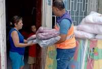 Funcionarios del Servicio Nacional de Gestión de Riesgos entregan ayuda humanitaria a una familia afectada por inundación en Esmeraldas