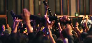 Fotograma del documental Estaci&oacute;n Polar, en que aparece el guitarrista Roger Ycaza sobre los hombros del p&uacute;blico en el Teatro M&eacute;xico. 