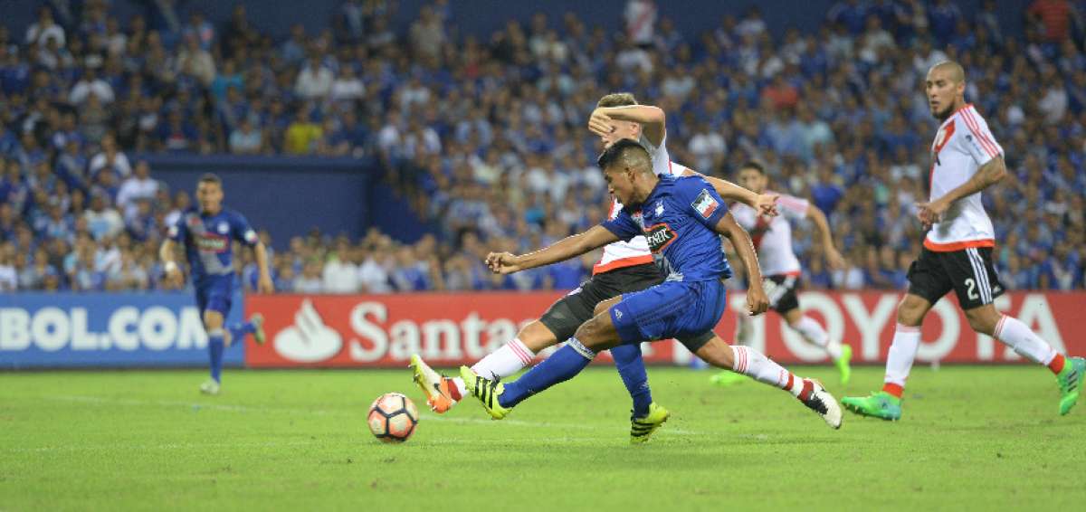 El delantero argentino de Emelec, Bruno Vides, intenta rematar al arco, pero tiene la marca de un defensor.  