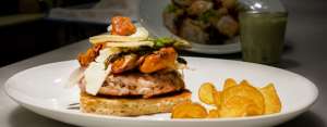 Hay algunas hamburguesas preparadas con cordero, acompa&ntilde;adas con cebolla caramelizada y esp&aacute;rragos.