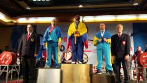 El levantador de potencia ecuatoriano Jos&eacute; Castillo (c.) festeja su medalla de oro con la bandera tricolor. Foto: Cortes&iacute;a 
