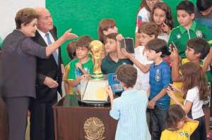 La mandataria recibe del presidente de la FIFA, Joseph Blatter, el trofeo mundialista. Foto: EFE.