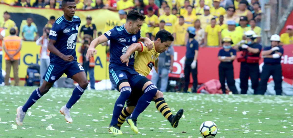 El capit&aacute;n de Barcelona, Mat&iacute;as Oyola -que volvi&oacute; a las canchas luego de ocho fechas- controla el bal&oacute;n ante la marca de dos jugadores de Emelec, la tarde de este domingo 14 de octubre en el Cl&aacute;sico del Astillero disputado por la fecha 14 del campeonato.