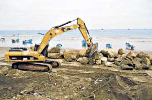 Maquinaria pesada coloca un muro de piedra escollera para evitar que los fuertes oleajes afecten el &aacute;rea del malec&oacute;n.  Foto: Cortes&iacute;a.