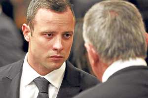 Pistorius (izq) dialoga con su abogado, Barry Roux, durante una de las &uacute;ltimas audiencias en Pretoria. Foto: AFP.