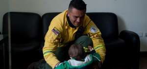 Uno de los param&eacute;dicos comparte con su hijo un momento. Para padres y madres bomberos es dif&iacute;cil dejar a la familia, pero saben que es su responsabilidad ayudar a otros. 