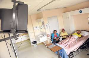 Leonor Campu&eacute;s (izq.), amiga, y Juana Lema, madre de Jonathan Oyagata, visitan al joven paciente mientras &eacute;l observa las acciones del cotejo Ecuador-Francia. Foto: &Aacute;lvaro P&eacute;rez.