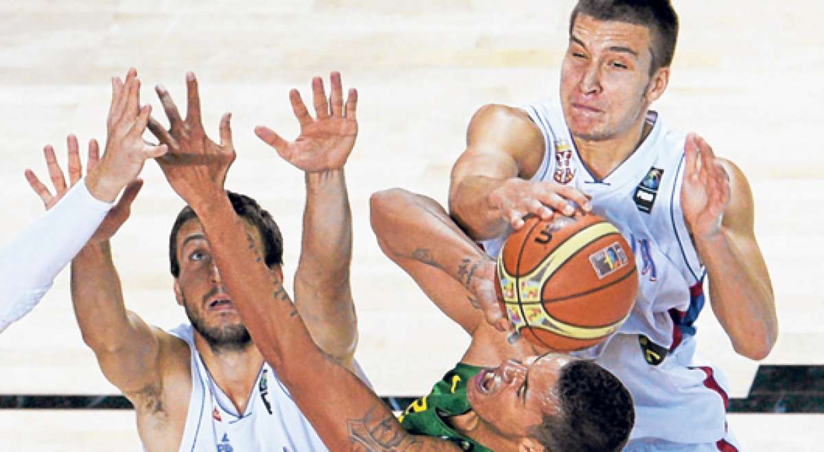 Rafael Hettsheimeir (abajo), de Brasil, es bloqueado por dos jugadores serbios durante el partido disputado ayer en Madrid. Foto: AFP.
